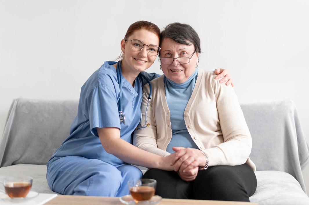 Acompañamiento integral y cuidado especializado de enfermería para adultos mayores en El Salvador: Una enfermera certificada de Juby Care abraza y sostiene la mano de una paciente mayor con compasión, brindando apoyo emocional para su bienestar y dignidad en el hogar.